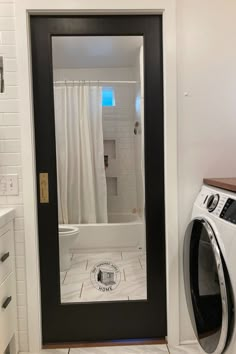 a washer and dryer in a small room with white tile flooring on the walls