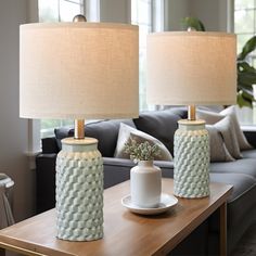 two lamps sitting on top of a wooden table