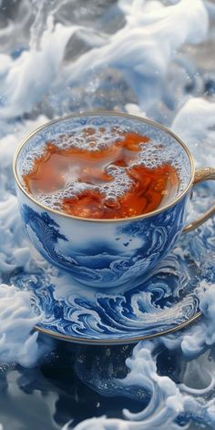 a blue and white cup filled with liquid sitting on top of a saucer covered in water