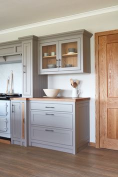 a kitchen with wooden floors and gray cabinets