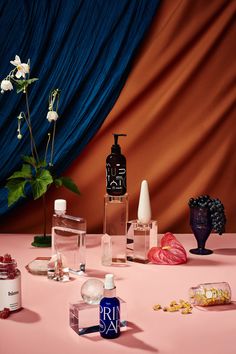 an assortment of perfumes on a pink table