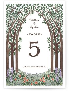 the wedding table numbers are surrounded by trees and flowers