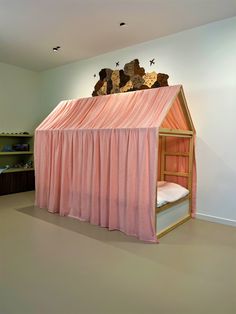 a bunk bed with pink curtains and teddy bears on top