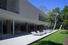 an empty lawn with lounge chairs in front of a building