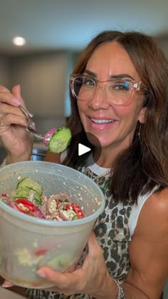 a woman holding a plastic bowl filled with food