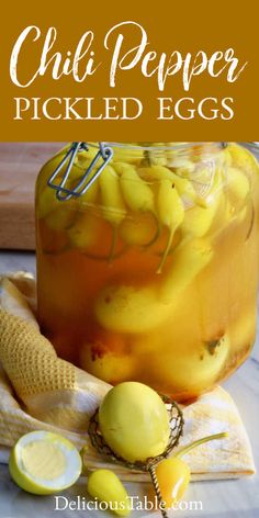 a jar filled with pickled eggs next to sliced lemons