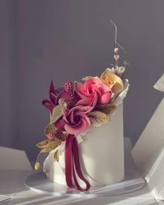 a white cake with pink and yellow flowers on top