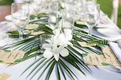 the table is set with white flowers and place cards