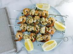 shrimp skewers with lemon wedges on a plate