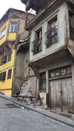 an old run down building with balconies on the second floor and stairs up to it