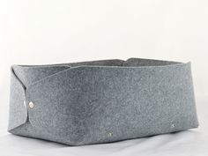 a gray felt basket sitting on top of a white table