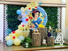 the table is set up with balloons, decorations and other items for snow white's birthday