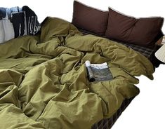 an unmade bed with several pillows on it