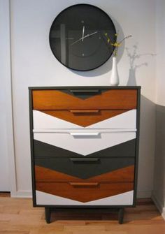 a black and white striped dresser next to a wall