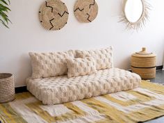 a couch sitting on top of a rug in a living room next to a mirror