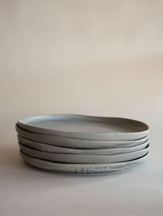 four plates stacked on top of each other in the shape of a bowl with wavy lines