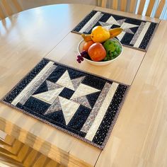 a bowl of fruit sitting on top of a table next to two placemats