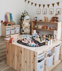 a wooden table with toy cars and toys on it in a playroom filled with children's toys