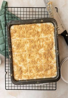 a pan filled with food sitting on top of a cooling rack next to utensils