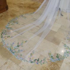 a wedding veil with flowers on the floor