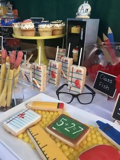 a table topped with lots of cakes and cupcakes