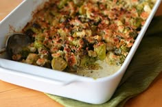 a casserole dish with broccoli and other toppings in it on a table