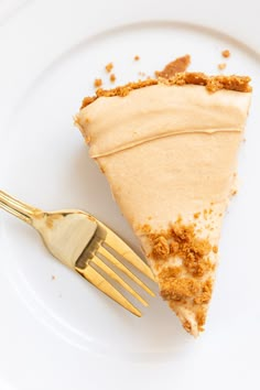 a piece of pie sitting on top of a white plate next to a gold fork