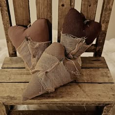 two brown pillows sitting on top of a wooden chair with burlocks around them