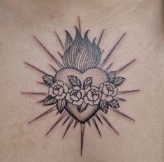 a woman's chest with flowers and a heart tattoo on the top of it