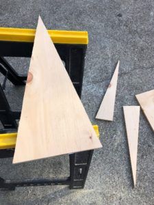 three pieces of wood sitting next to each other on the ground with tools in front of them