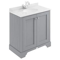 a white sink sitting next to a gray cabinet