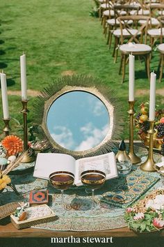 a table topped with an open book and lots of candles