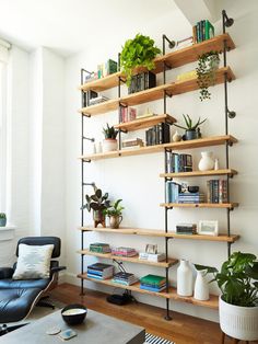 a living room filled with lots of books and plants