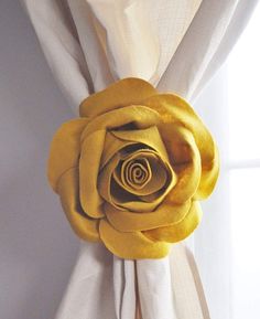 a yellow rose on the side of a curtain