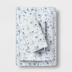 a white and blue floral print sheet set with two matching pillow cases, folded on top of each other