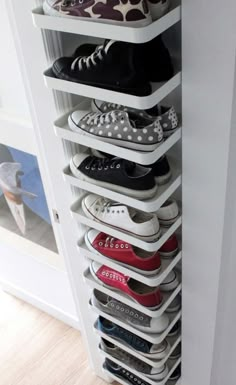 a white shoe rack with several pairs of shoes on it