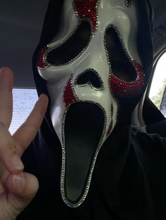 a person wearing a white mask with red accents