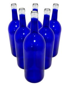 six blue glass bottles are lined up in a row