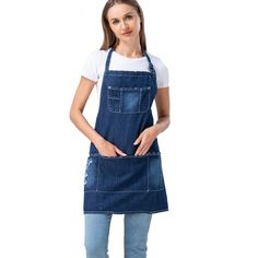 a woman wearing an apron and denim overalls with her hands in her pockets, posing for the camera