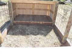 a dog house built into the side of a fenced in area with wood and wire