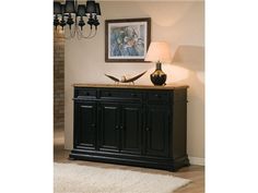 a black buffet table with two lamps and a painting on the wall in front of it