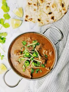 a pot filled with meat and broccoli next to some pita bread