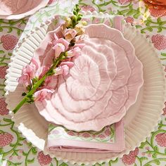 a pink plate with flowers on it and napkins