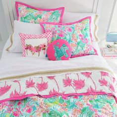 a bed topped with lots of colorful pillows