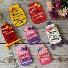 six handmade magnets with different sayings on them and flowers in the background