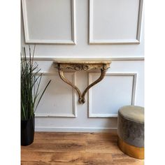 a plant is sitting next to a wall shelf with a potted plant on it