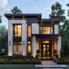 a modern house with lots of windows and lights on the front door, surrounded by greenery