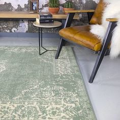 a green area rug in front of a wooden table with two chairs and a potted plant