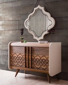 a dresser with a mirror on top of it next to a wooden floor and wall