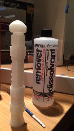 a bottle of glue sitting on top of a table next to a tube of toothpaste